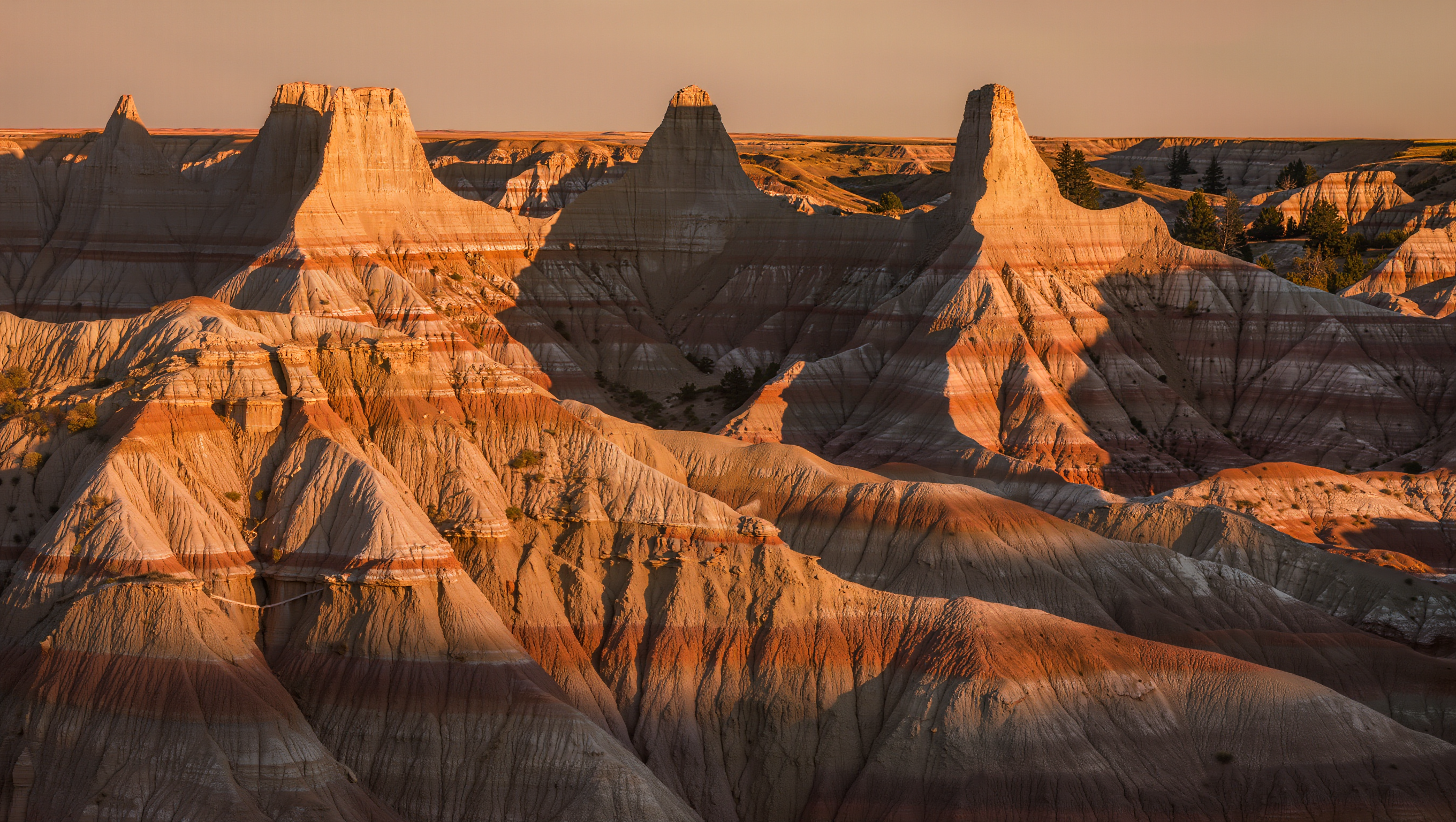 Panoramic view of the rugged North Dakota Badlands with layered rock formations at golden hour